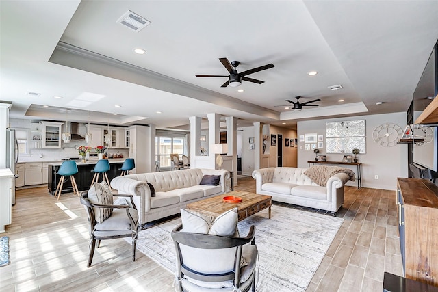 living room with wood tiled floor, a raised ceiling, visible vents, and recessed lighting