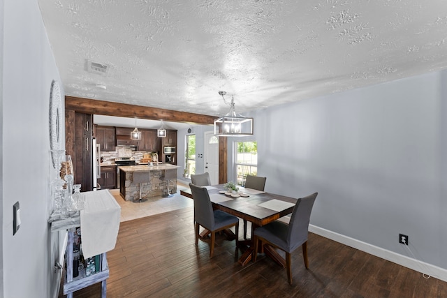 dining space with a textured ceiling, sink, and dark hardwood / wood-style floors