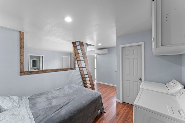 bedroom featuring a wall mounted air conditioner, hardwood / wood-style flooring, and separate washer and dryer