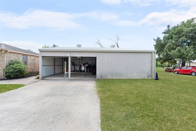 exterior space featuring a front yard, a garage, and an outbuilding