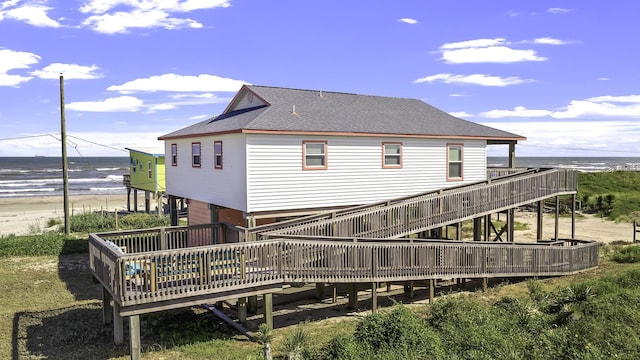 back of property featuring a deck with water view