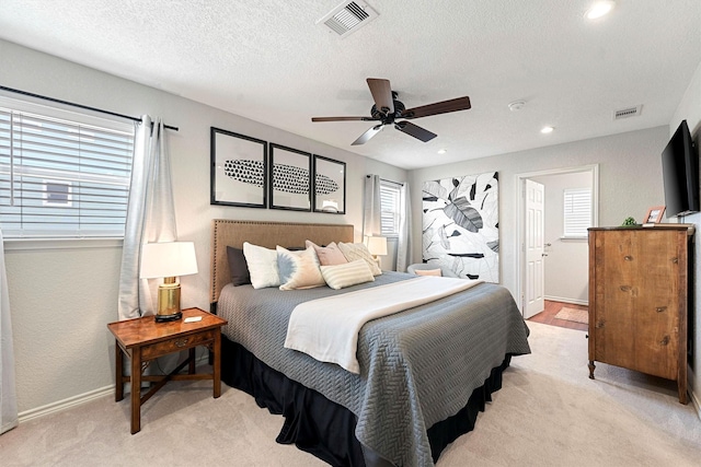 carpeted bedroom with a textured ceiling and ceiling fan