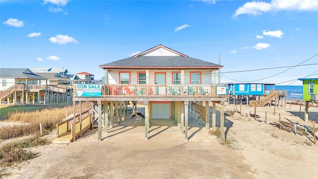 114 Coral Ct, Surfside Beach, TX 77541 - back of property with a carport, a shingled roof, an attached garage, and stairway