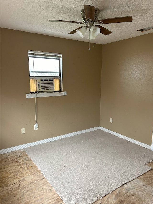 spare room with a textured ceiling, cooling unit, and ceiling fan