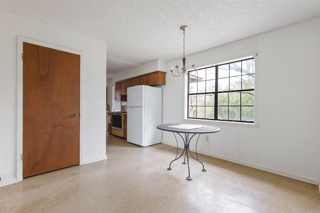 unfurnished dining area with a textured ceiling and a chandelier