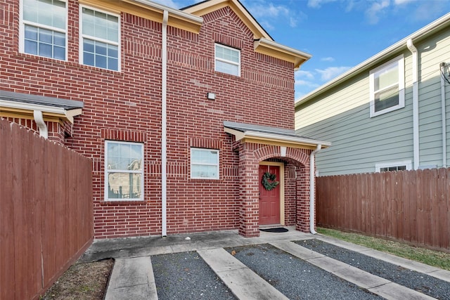 view of front of house with fence and brick siding