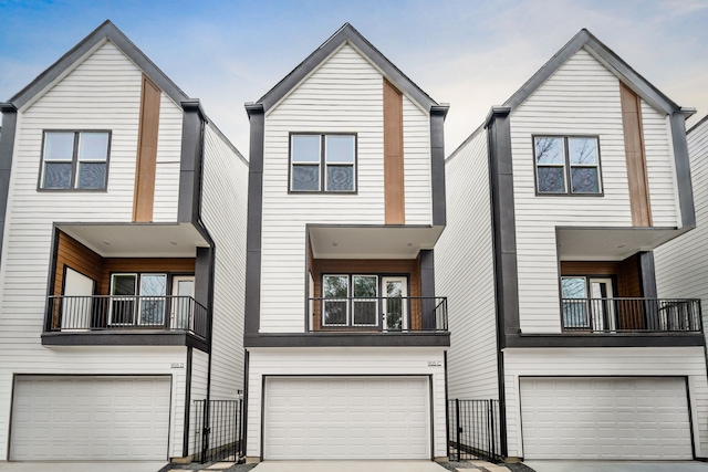 view of front of home featuring a garage, driveway, and a balcony