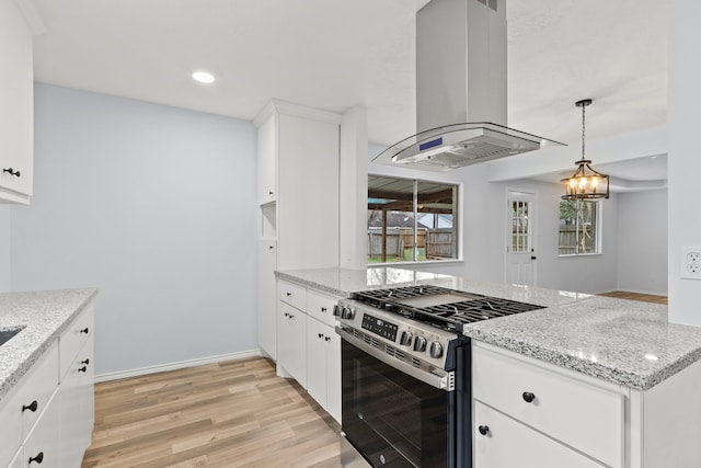 kitchen featuring white cabinets, light stone countertops, island exhaust hood, and stainless steel gas range