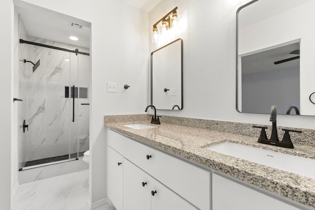 bathroom with toilet, vanity, and a shower with shower door