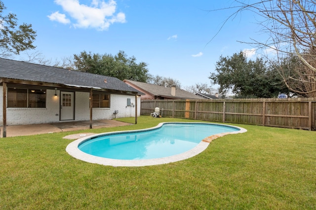 view of swimming pool featuring a patio and a yard