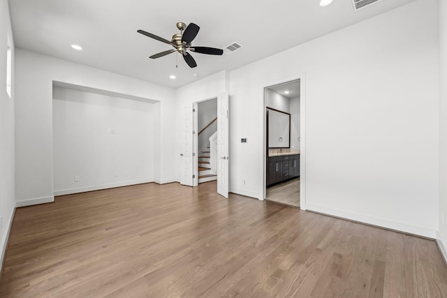 unfurnished bedroom with ceiling fan, connected bathroom, and hardwood / wood-style floors