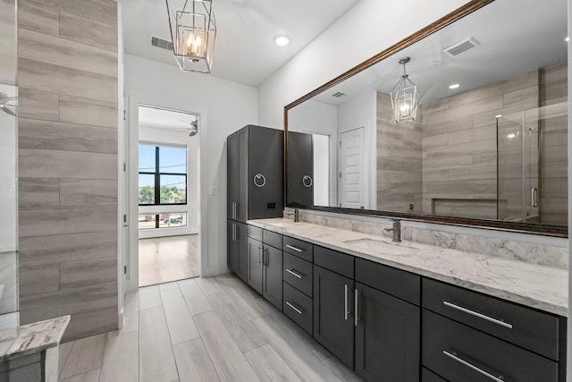 bathroom featuring ceiling fan, vanity, and a shower with door