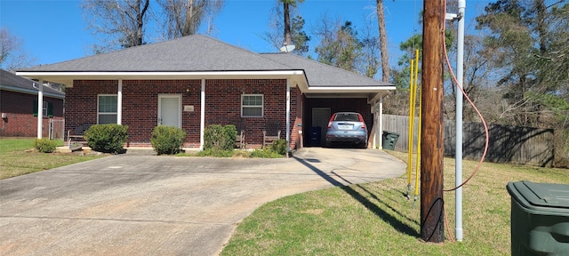 view of front of house with brick siding, fence, a carport, driveway, and a front lawn