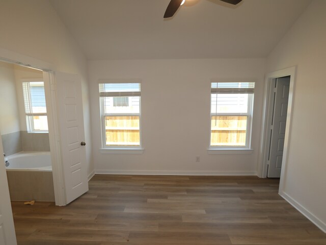 31911 Splendor Dr, Fulshear, TX 77441 - unfurnished bedroom featuring lofted ceiling, multiple windows, wood finished floors, ceiling fan, and baseboards
