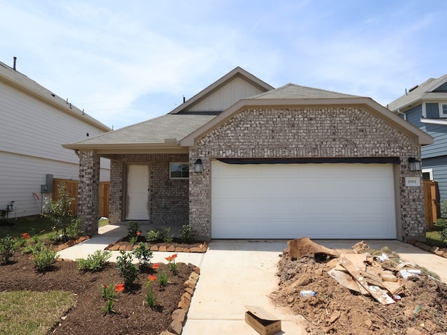 31911 Splendor Dr, Fulshear, TX 77441 - view of front of home featuring driveway, brick siding, a garage, roof with shingles, and board and batten siding