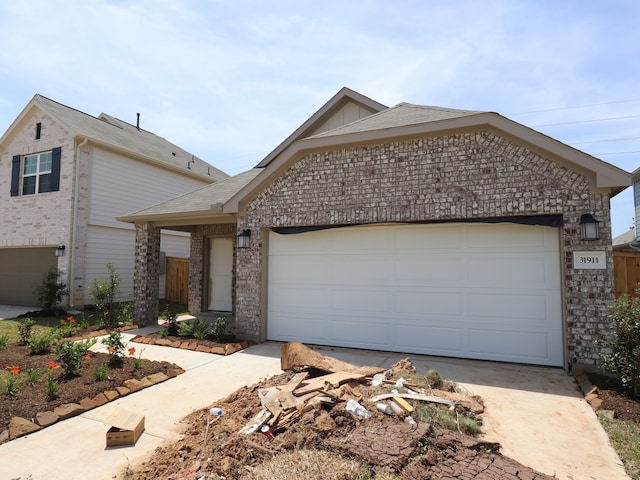 31911 Splendor Dr, Fulshear, TX 77441 - view of front facade featuring concrete driveway, brick siding, an attached garage, and roof with shingles