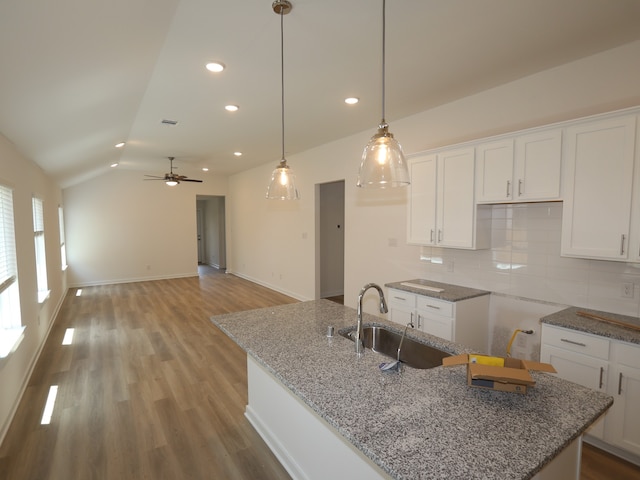 31911 Splendor Dr, Fulshear, TX 77441 - kitchen with a sink, white cabinets, vaulted ceiling, decorative backsplash, and recessed lighting
