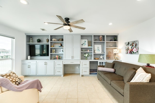 living room with ceiling fan, light tile patterned flooring, and built in desk