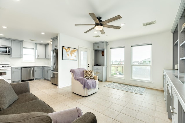 living room with ceiling fan and light tile patterned floors