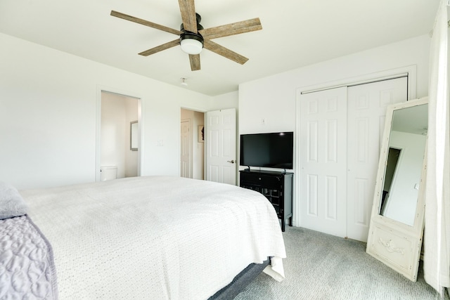 bedroom featuring a closet, light colored carpet, ceiling fan, and ensuite bath