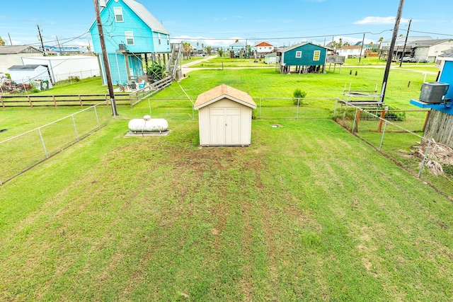 view of yard featuring central air condition unit and a storage shed