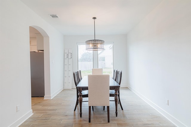 dining space featuring light hardwood / wood-style floors and an inviting chandelier