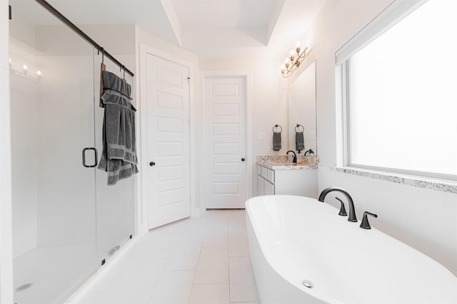 bathroom with plus walk in shower, tile patterned flooring, and vanity