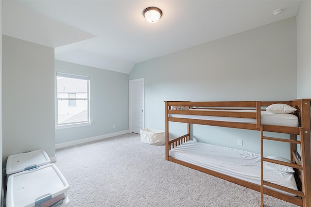 unfurnished bedroom with vaulted ceiling and carpet floors