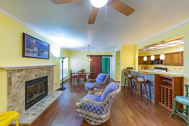 living room featuring crown molding, dark hardwood / wood-style floors, ceiling fan, and a premium fireplace