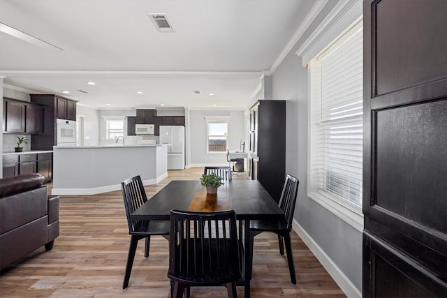 1623 Bay Meadows St, Galveston, TX 77554 - dining space featuring ornamental molding, baseboards, visible vents, and light wood-type flooring