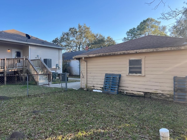 back of house with a deck and a yard