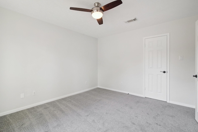 carpeted spare room featuring ceiling fan