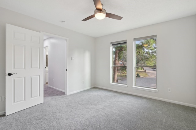 carpeted spare room featuring ceiling fan