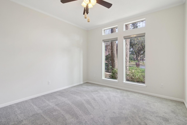 empty room featuring crown molding, light colored carpet, and ceiling fan