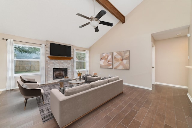 living room featuring ceiling fan, beamed ceiling, high vaulted ceiling, and a brick fireplace