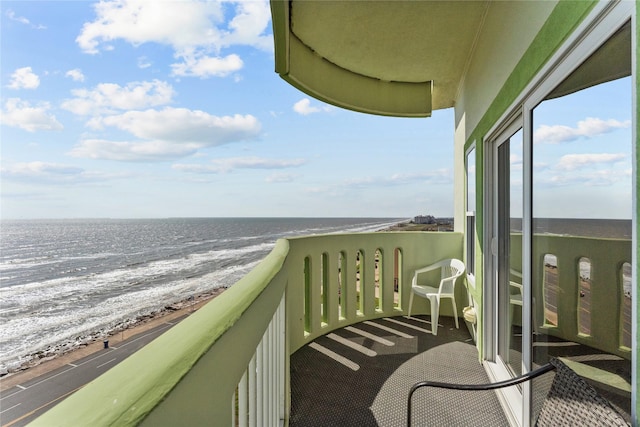 balcony featuring a water view and a view of the beach