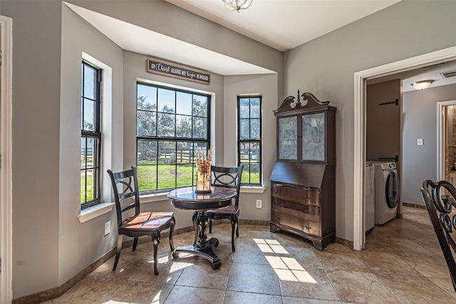 living area with washing machine and dryer, visible vents, and baseboards