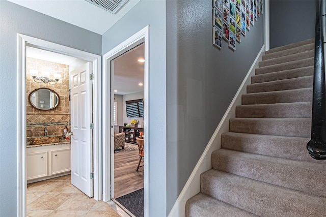 staircase with visible vents and baseboards