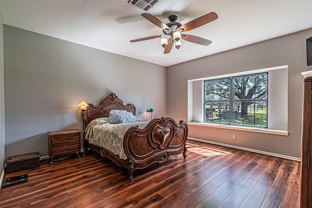 bedroom featuring baseboards, wood finished floors, visible vents, and a ceiling fan