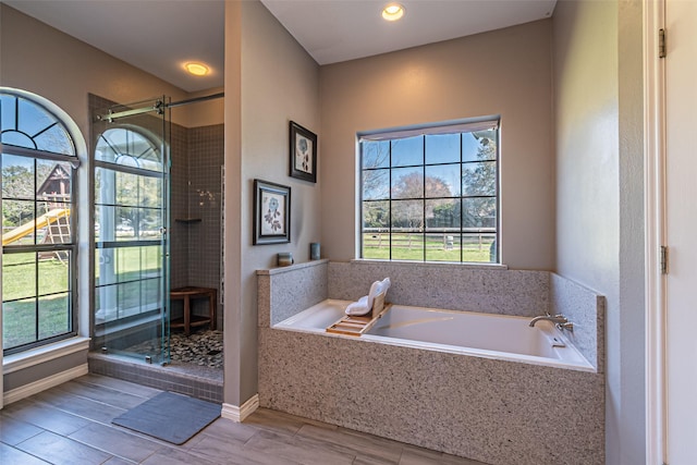 full bath with a garden tub, plenty of natural light, and a shower stall