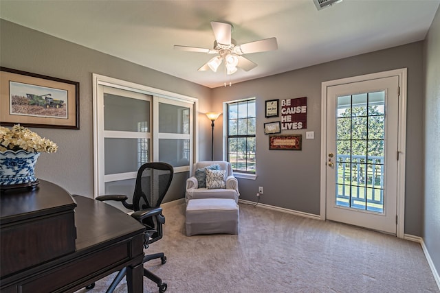 carpeted office with a ceiling fan, baseboards, and a wealth of natural light