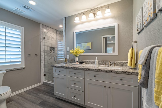 full bathroom with toilet, wood finished floors, visible vents, and a shower stall