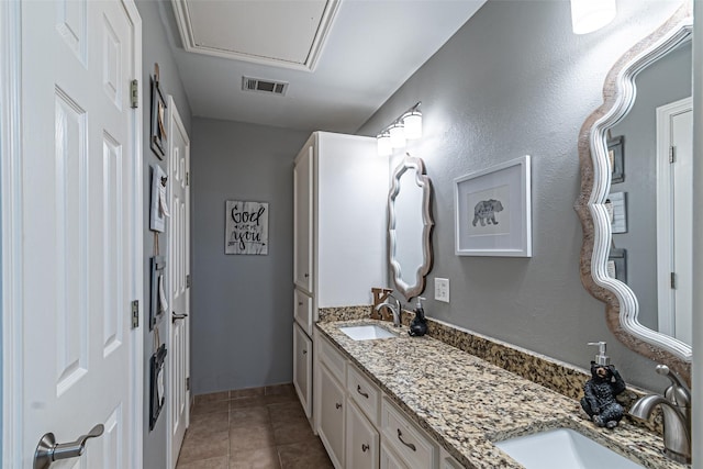 bathroom featuring double vanity, visible vents, a sink, and tile patterned floors