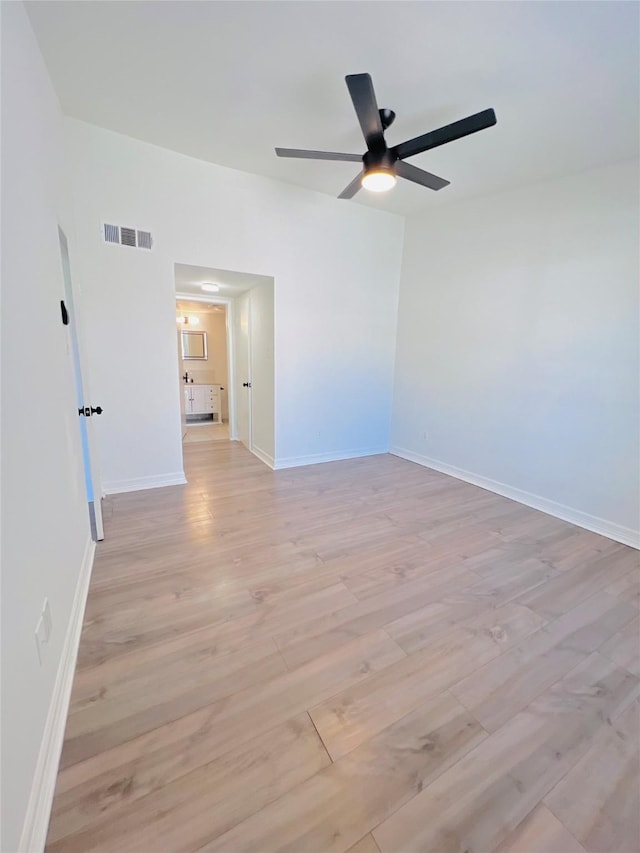 unfurnished room featuring light wood-style floors, visible vents, ceiling fan, and baseboards