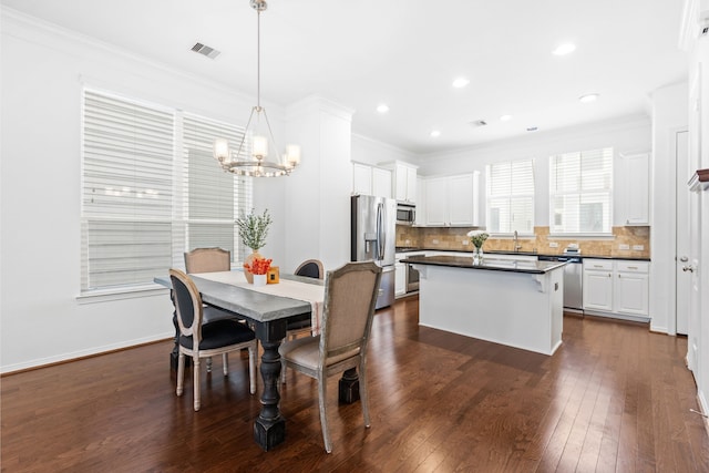 dining area featuring dark wood-style floors, baseboards, recessed lighting, crown molding, and a notable chandelier