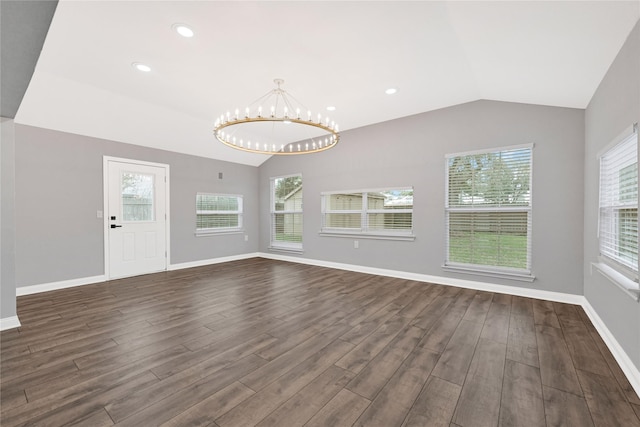 interior space with vaulted ceiling, an inviting chandelier, and dark hardwood / wood-style flooring