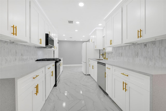 kitchen featuring sink, white cabinets, stainless steel appliances, and decorative backsplash