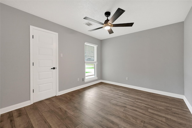 empty room with ceiling fan and dark hardwood / wood-style floors