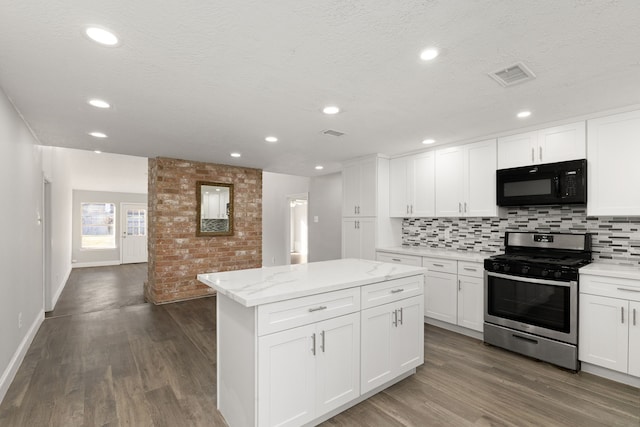 kitchen with a kitchen island, white cabinets, gas stove, and decorative backsplash