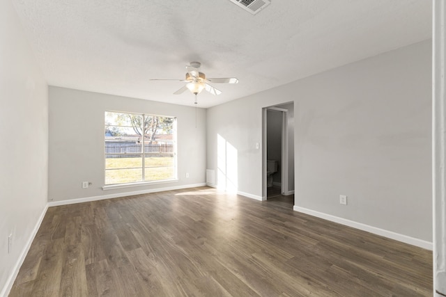 empty room featuring dark hardwood / wood-style flooring, ceiling fan, and a textured ceiling